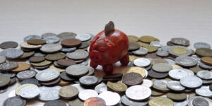 kleines Glückschwein und viele Münzen Sparen